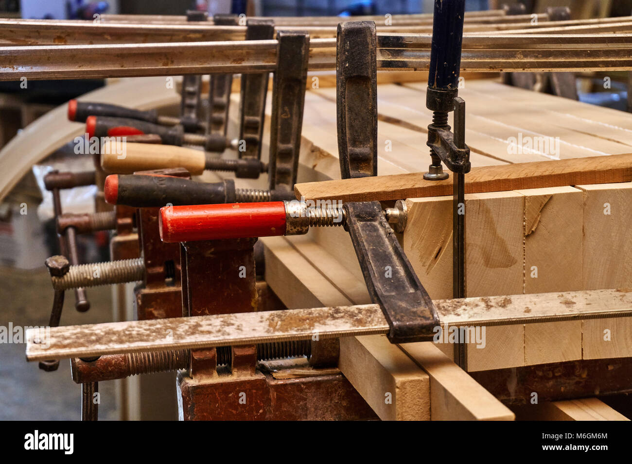 Joinery. Gluing and clamping wooden detail in Production of wood furniture. Furniture