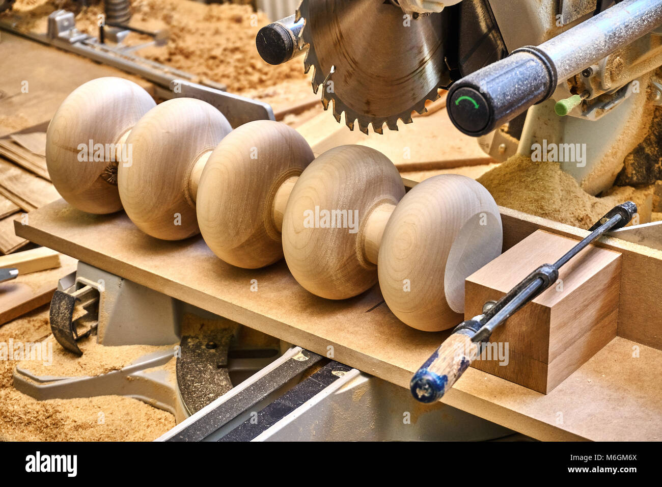Joinery. Cut wooden leg with miter saw in Wooden furniture