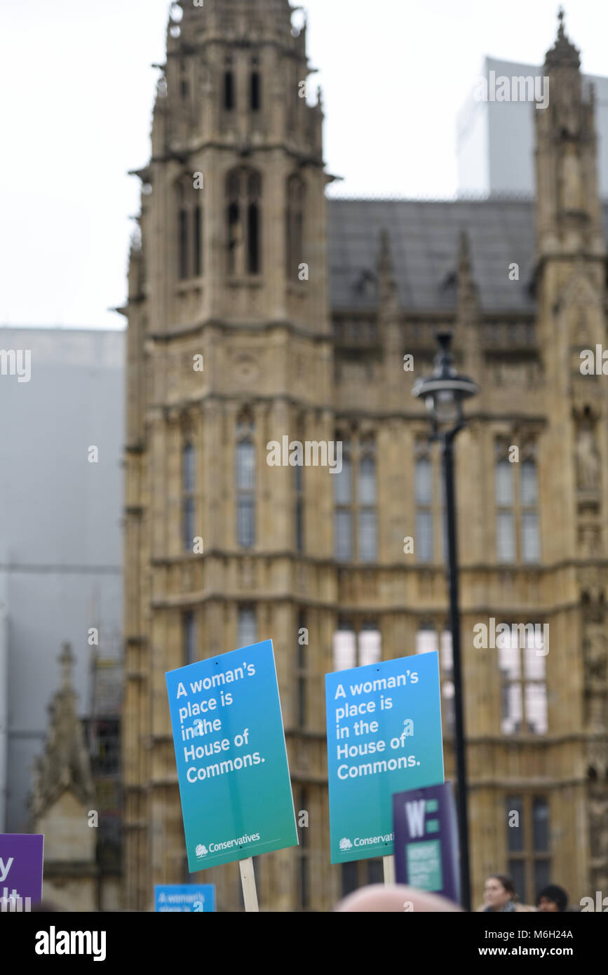 A woman's place is in the House of Commons placards. March 4 Women organised by Care International. Protesters gathered in Old Palace Yard, Palace of Westminster Stock Photo