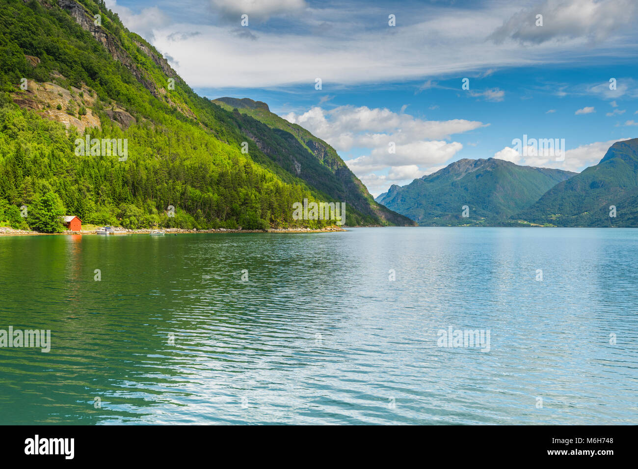 small red hut at the shore of the fjord, Norway, Lustrafjorden, Sognefjorden Stock Photo