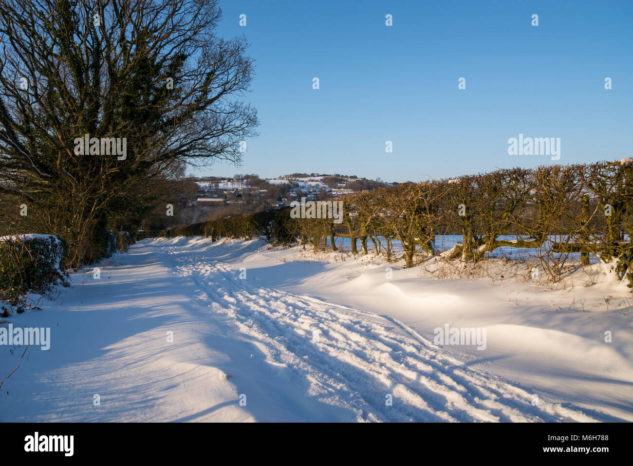 Deep snow on a country lane in the English countryside. Stock Photo