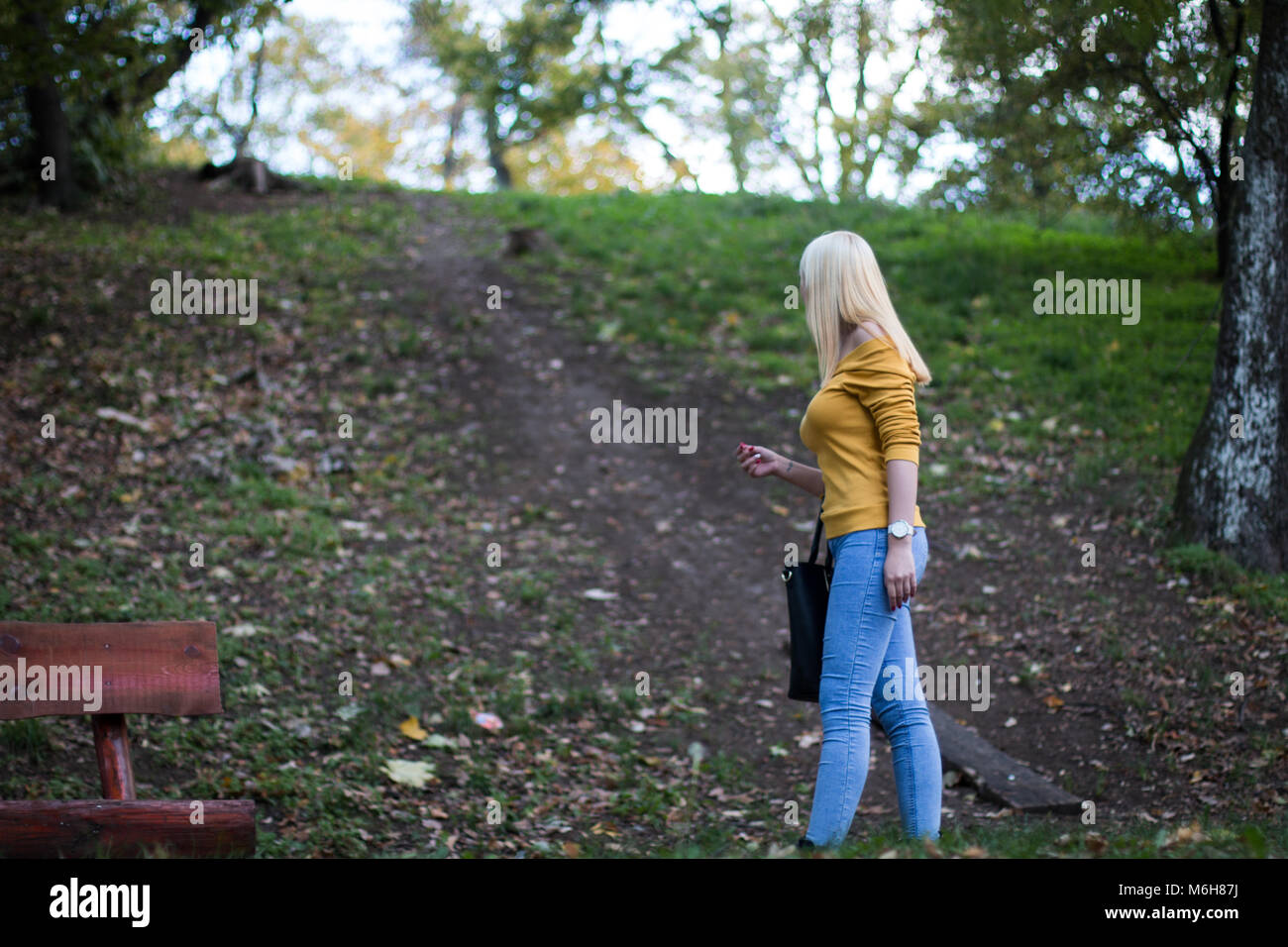 Young blonde woman taking a walk in the forest Stock Photo - Alamy