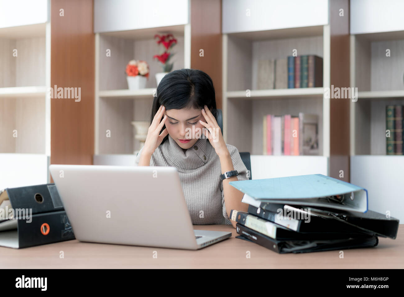 Portrait of tired young Asian business woman feeling stress from a lot of work. Stress at work and emotional pressure concept. Stock Photo