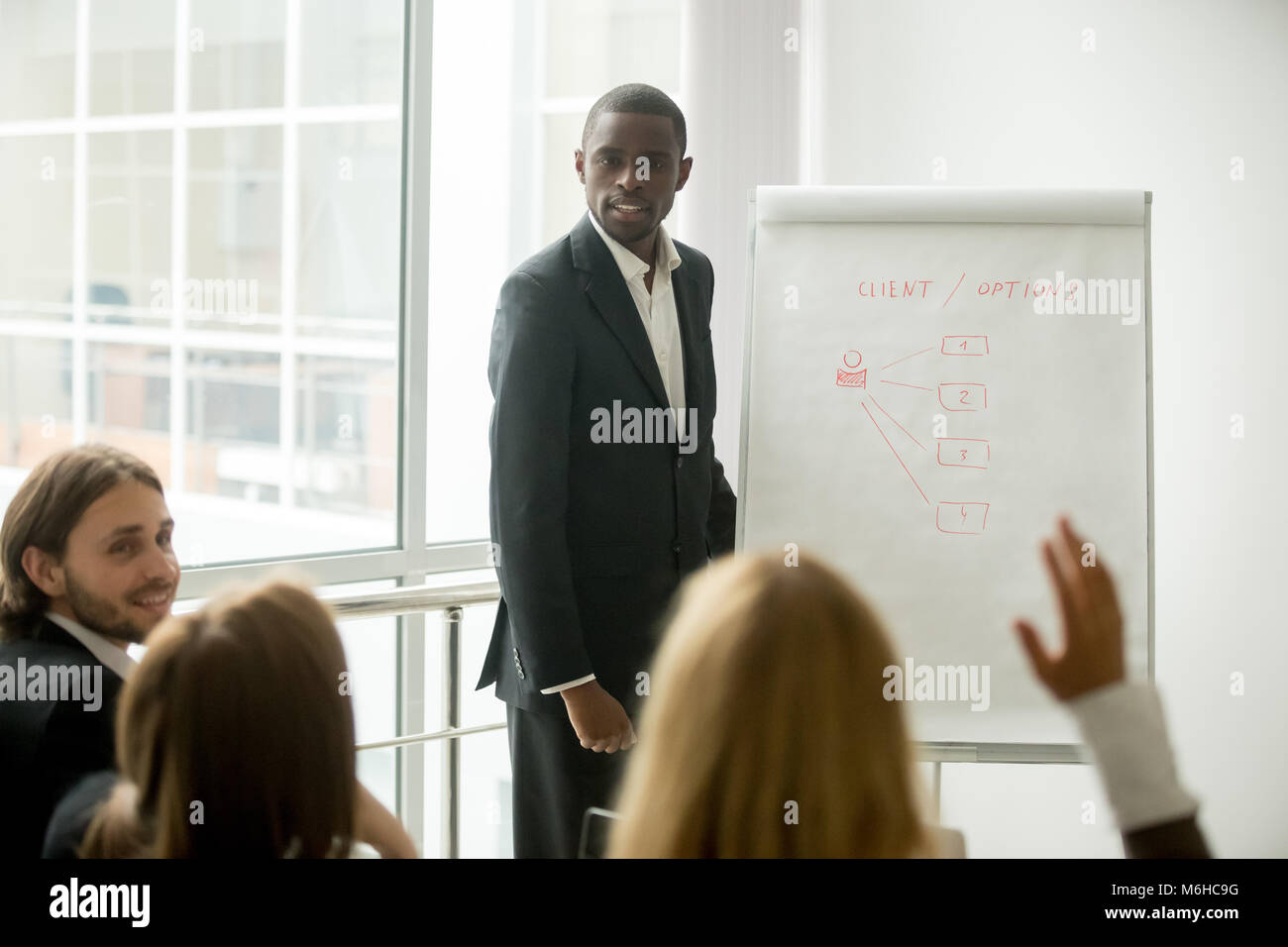 Business audience asking african presenter speaker questions at  Stock Photo