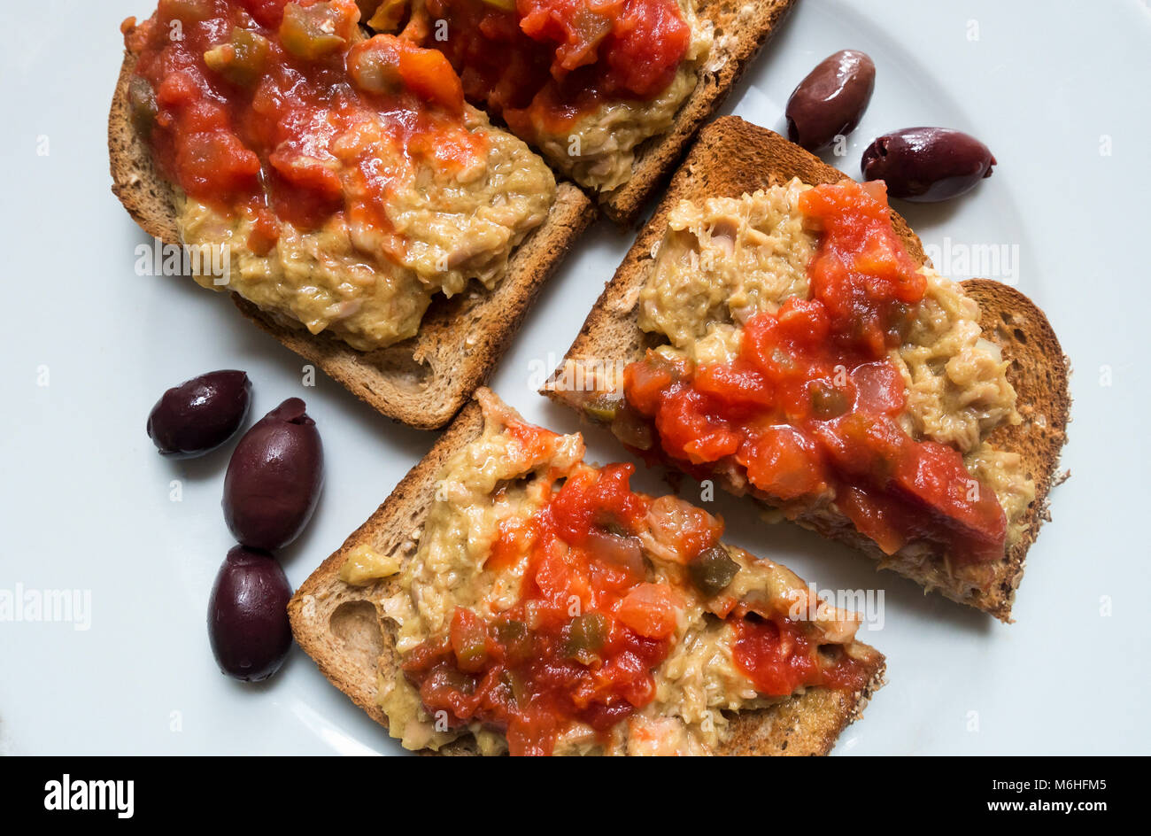 Tuna salad on whole wheat toast with salsa fresca and kalamata olives Stock Photo