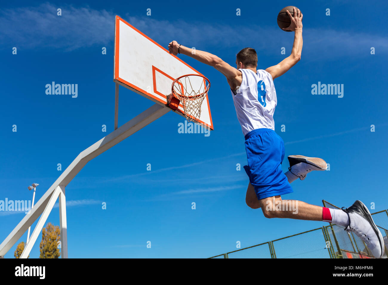 Young Basketball street player making slam dunk Stock Photo
