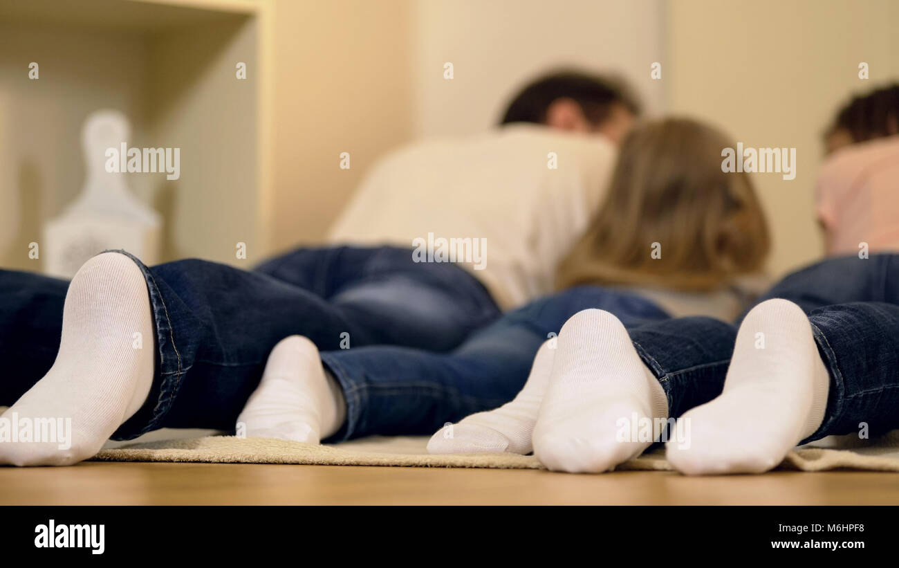 Perfect family lying on floor together, enjoying weekend leisure, happy memories Stock Photo