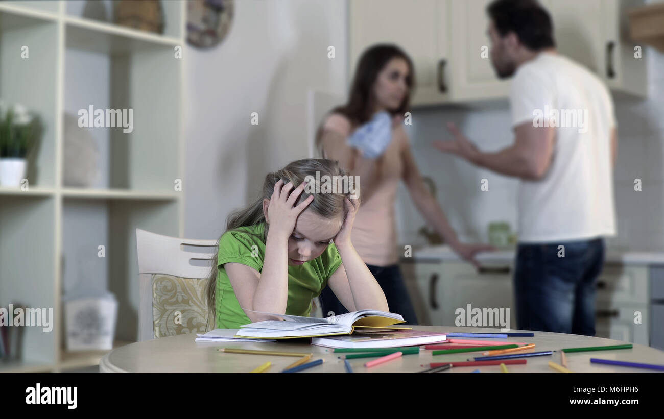 Upset child listening divorcing parents fight, suffering from conflict in family Stock Photo