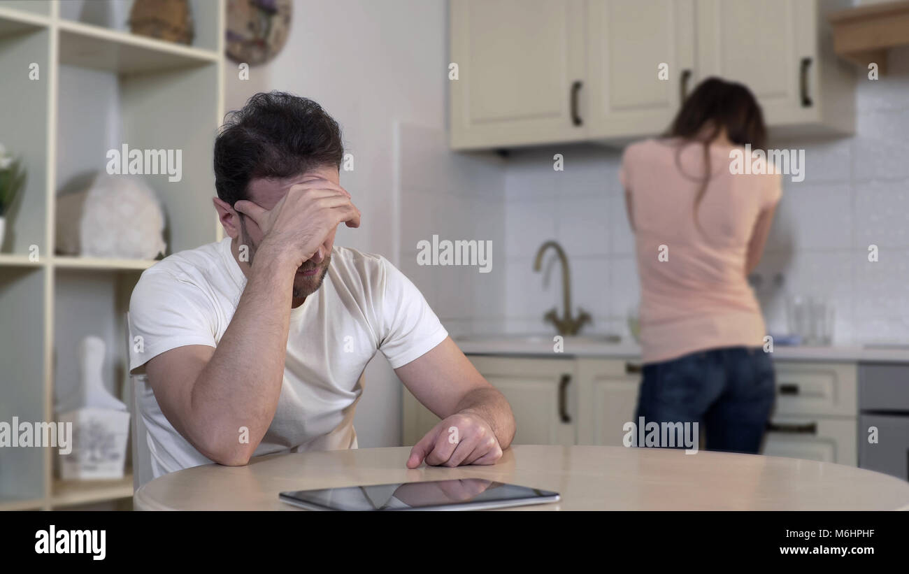 Nervous wife crying quarreling with man, annoyed husband ignoring wife, breakup Stock Photo