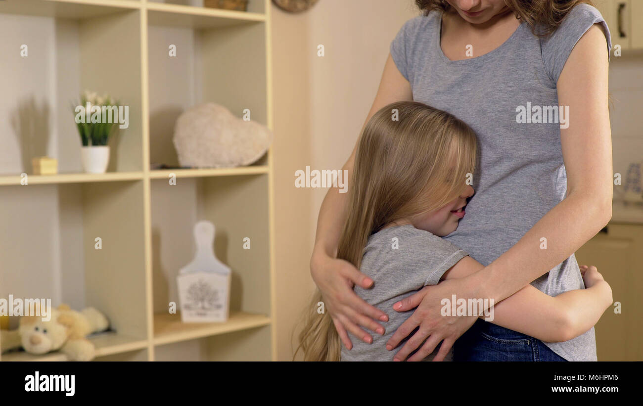 Cute little girl hugging her mother after long separation, family relationship Stock Photo