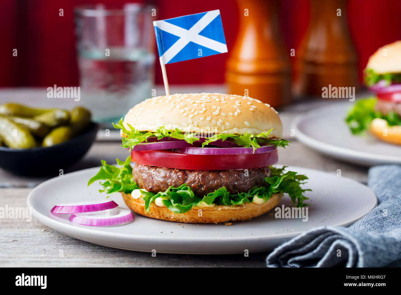 Burger on a plate with pickles. Wooden background. Stock Photo