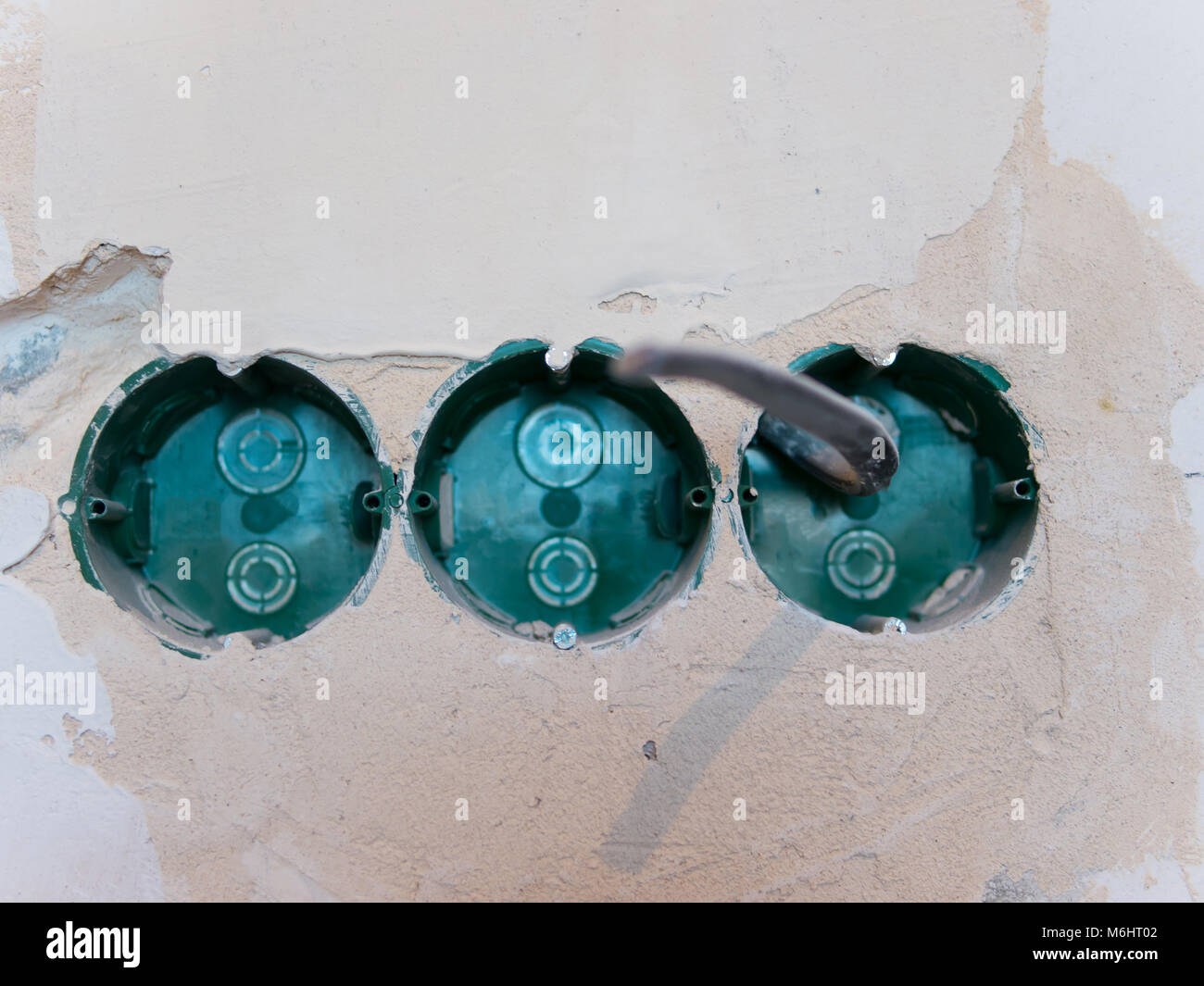 power socket hole in concrete wall with electrical wiring Stock Photo