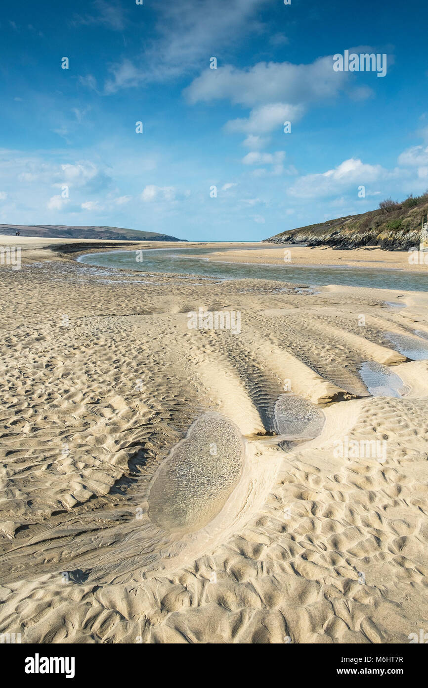 The tidal Gannel River at low tide flowing across the beach at Crantock in Newquay Cornwall. Stock Photo