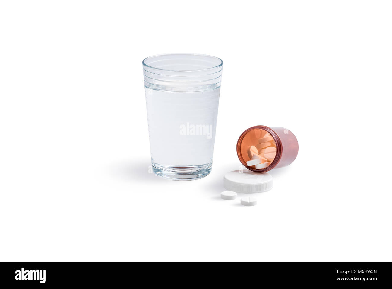 A glass of water with an open bottle of painkillers isolated on a white background. Stock Photo