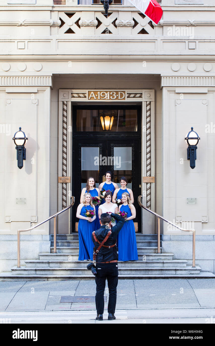 Bride and bridesmaids posing for a photographer in downtown Vancouver