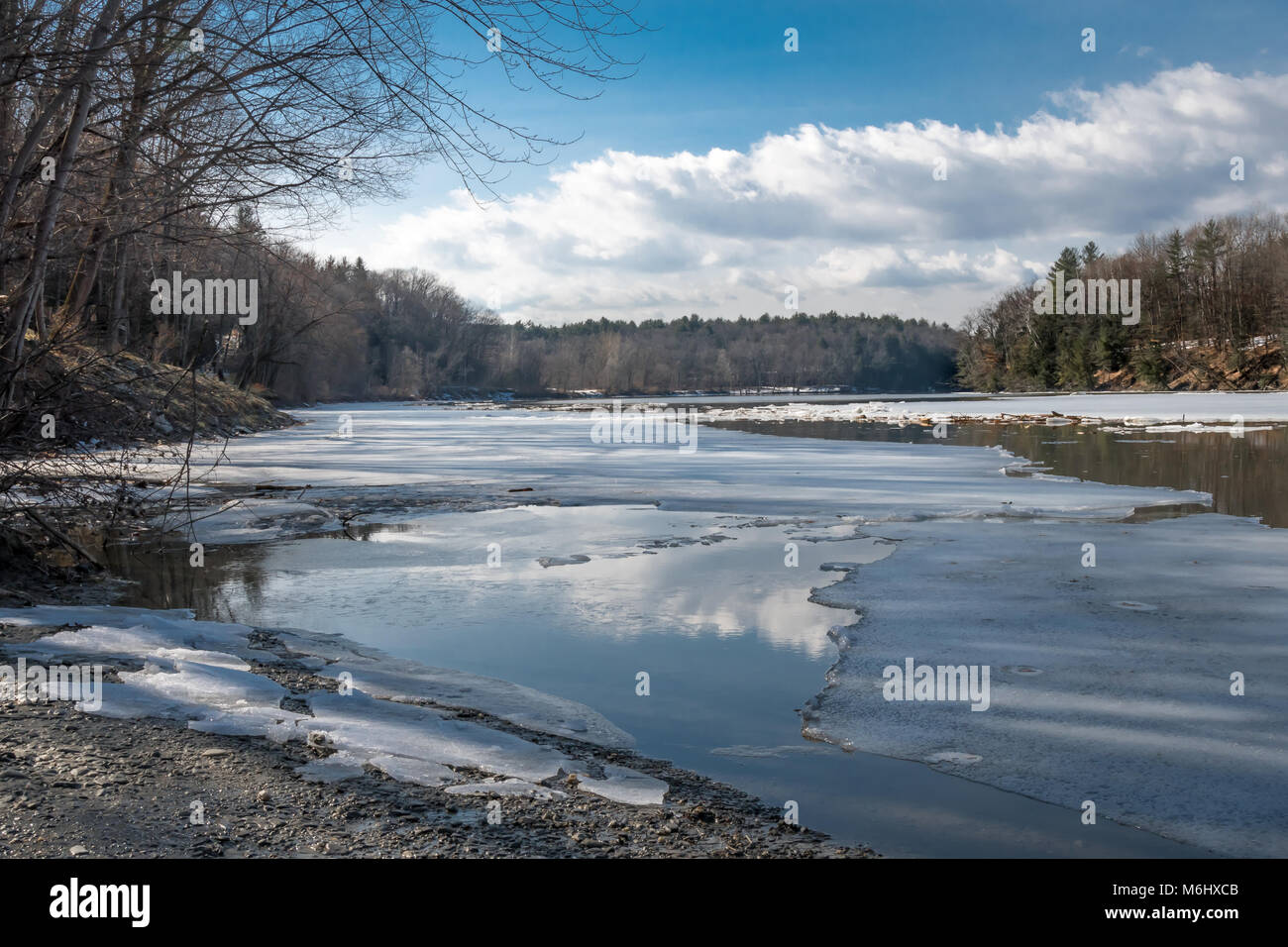 Winter’s heading out: Ice floes break up and flow south on the Connecticut River during a recent sunny late winter day in West Chesterfield, NH. Stock Photo