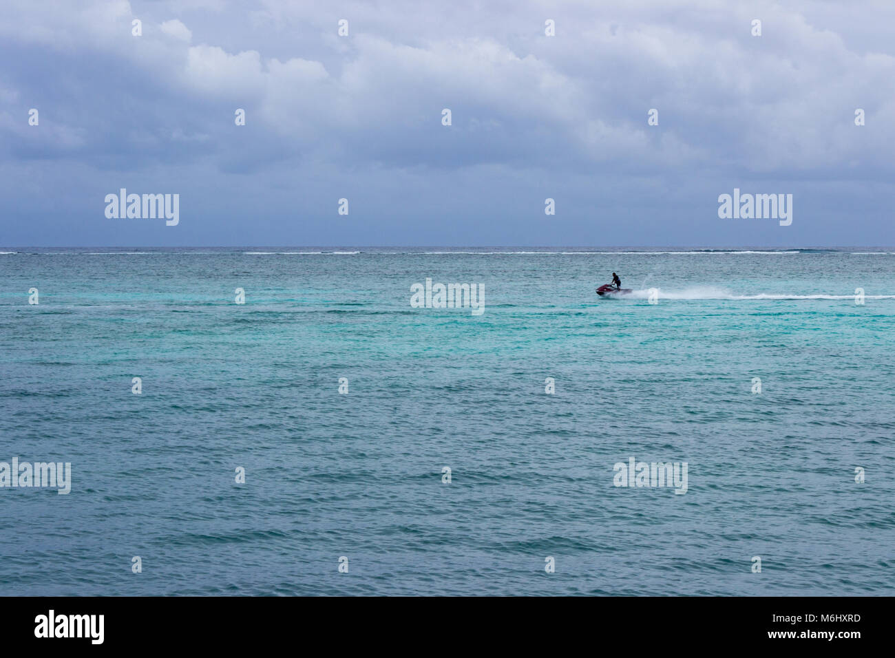 A jet ski races across the Caribbean inside the Meso-American reef. Stock Photo