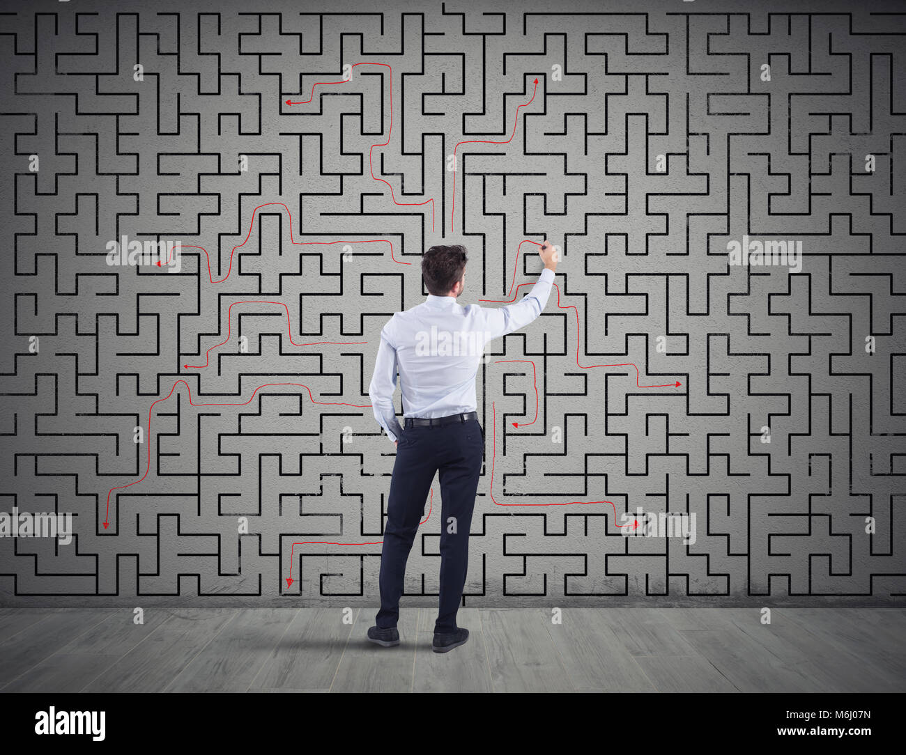 Businessman draws the solution of a labyrinth. Concept of problem solving Stock Photo
