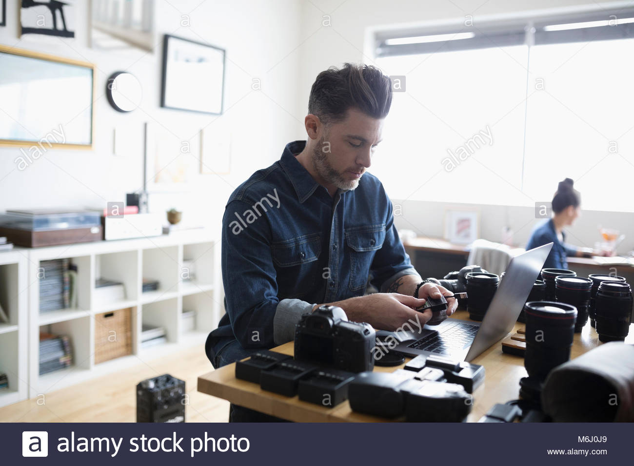 Male photographer with equipment at laptop Stock Photo Alamy