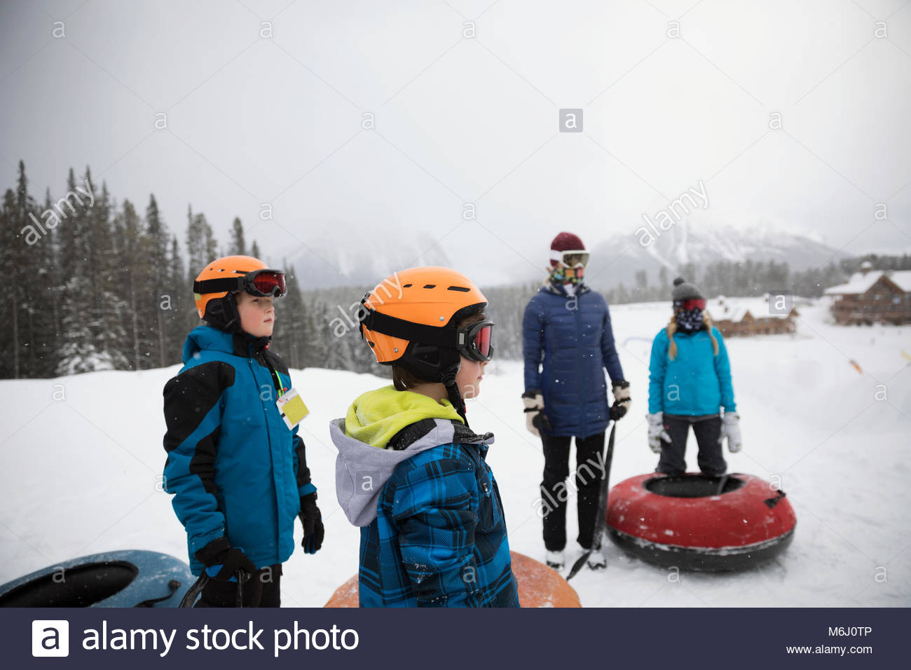 Family inner tubing in snow at tube park Stock Photo Alamy