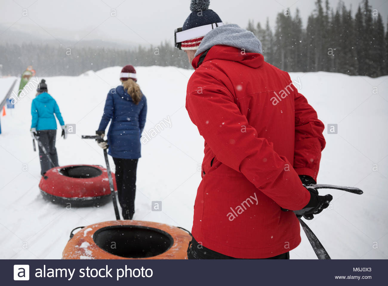 Family pulling inner tubes in snow at tube park Stock Photo Alamy