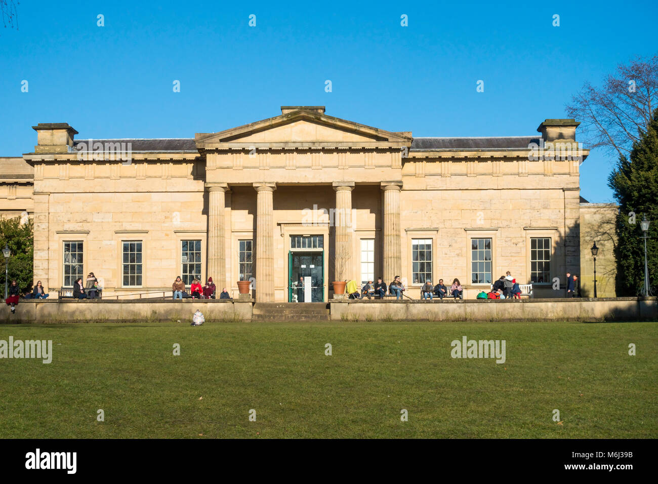 People enjoying winter sunshine outside The Yorkshire Museum in museum park York City Centre  England Stock Photo