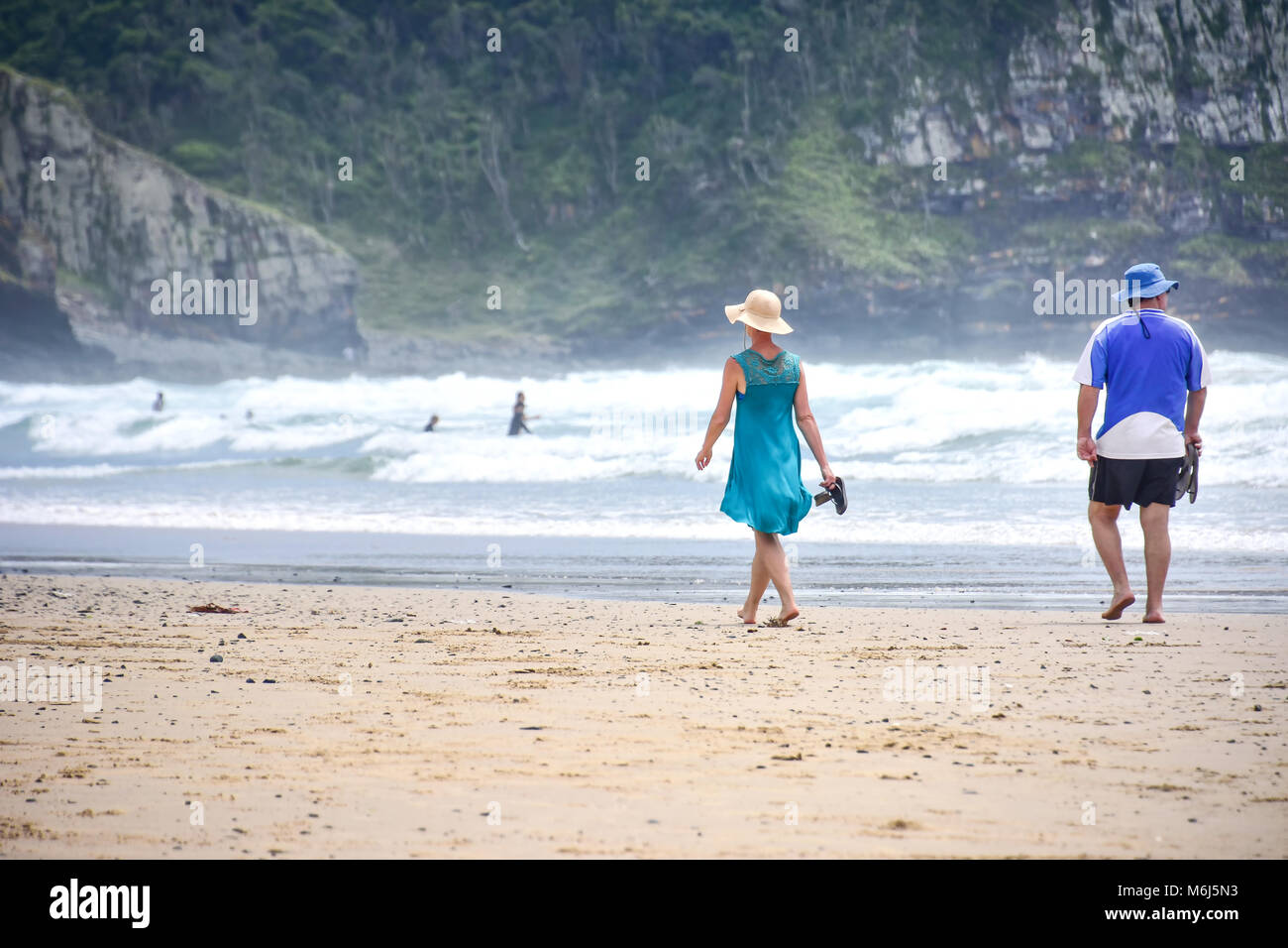 A couple walking on the beach in Coffee Bay at the Indian Ocean in the Eastern Cape at the Wild Coast of South Africa Stock Photo