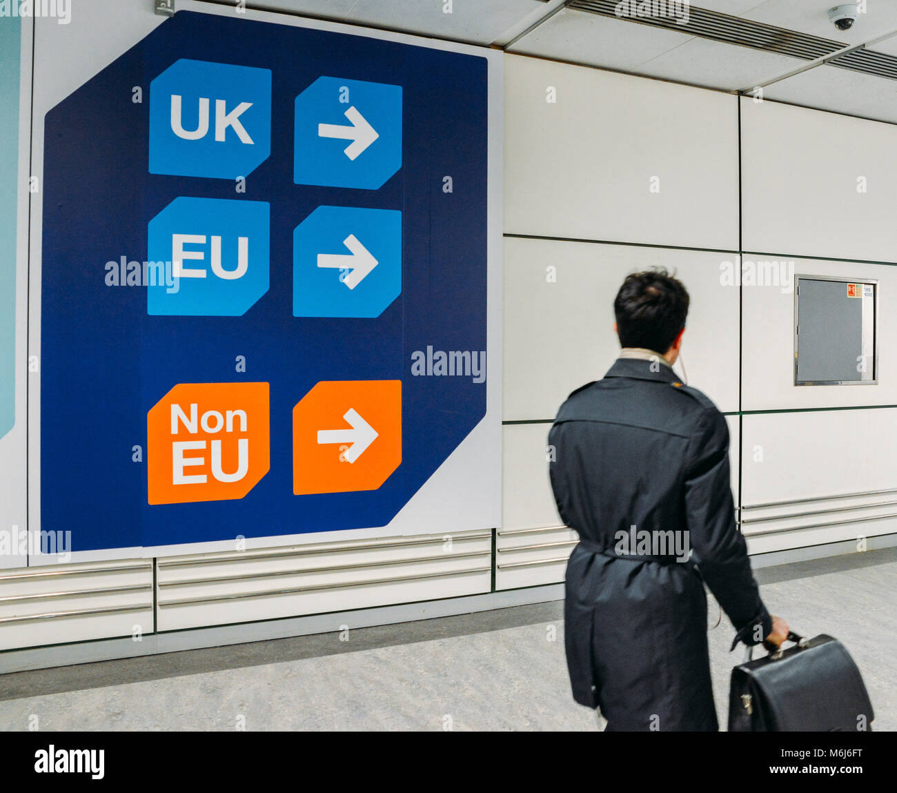 Passenger walks past sign prior to immigration control pass a sign pointing towards queues for UK, EU and Non-EU passport holders. In April 2019, UK is set to leave the European Union - Brexit theme Stock Photo