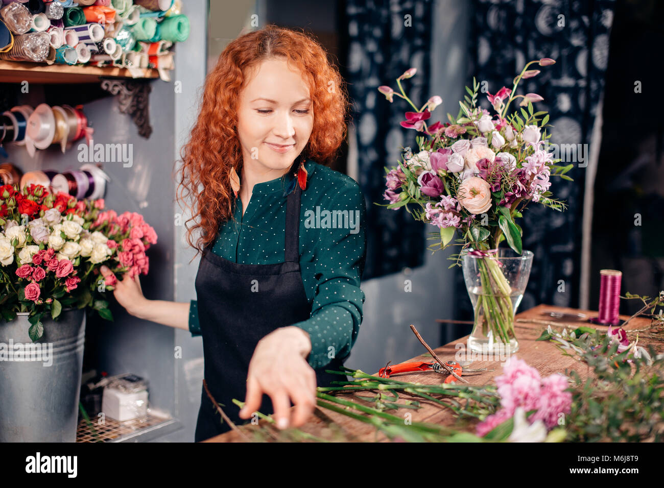snapshot of goodlooking floral assistant counting flowers for bouquet