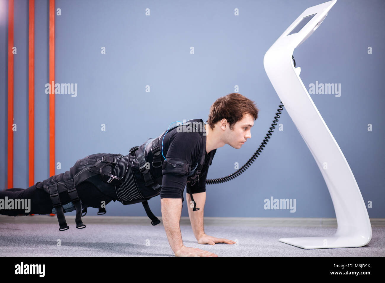 https://c8.alamy.com/comp/M6JD9K/man-in-electrical-muscular-stimulation-suits-doing-plank-exercise-M6JD9K.jpg