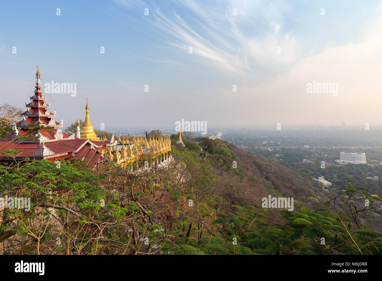 Panoramic view of pavilions and golden pagodas at the Mandalay Hill and the city below in Mandalay, Myanmar (Burma) on a sunny day. Stock Photo