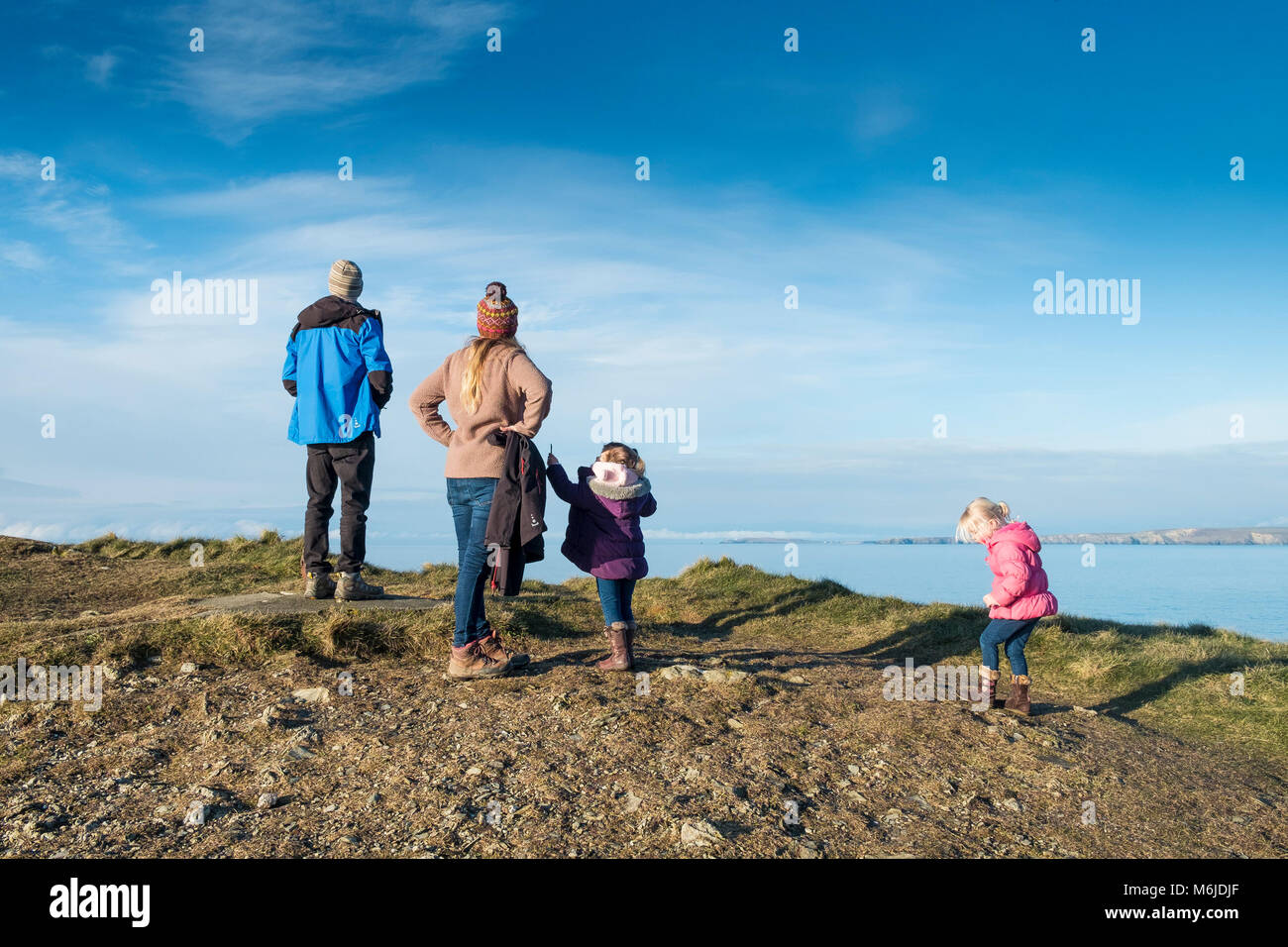A family standing on Towan Head and enjoying the view over Newquay Bay in Cornwall. Stock Photo