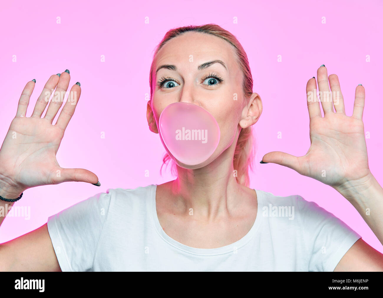 girl with chewing gum on a pink background with glasses Stock Photo Alamy