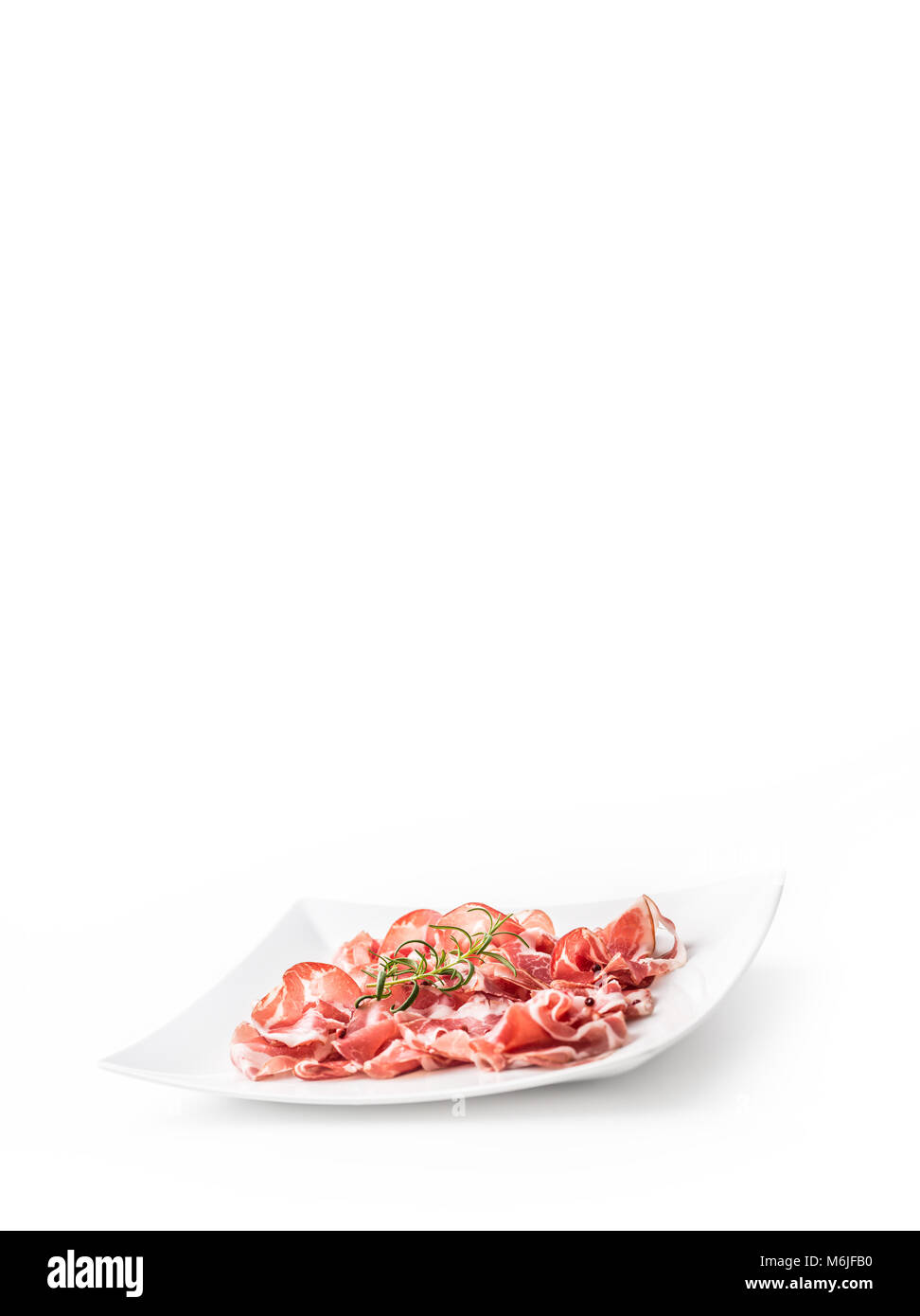 Prosciutto. Curled slices of delicious italian prosciutto with rosemary