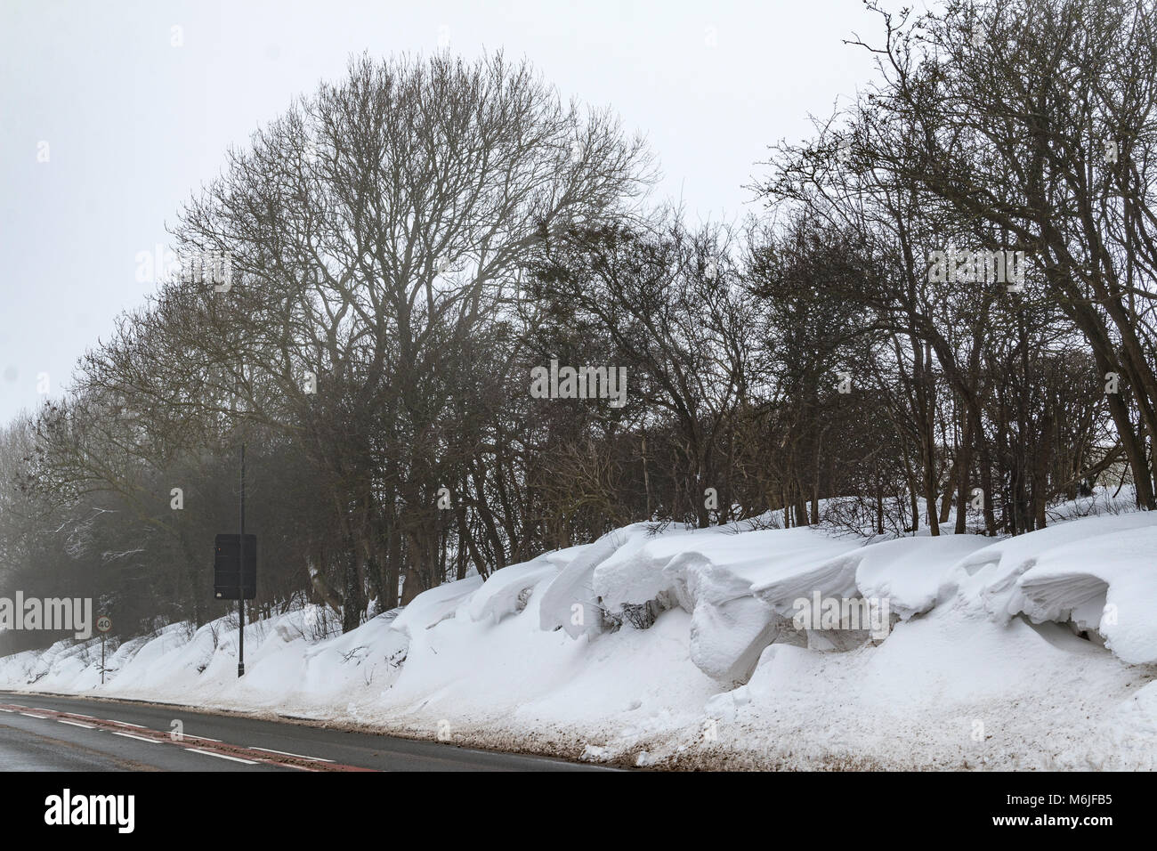 An image taken on a winters morning of snowdrifts at the side of the road, Kibworth Harcourt, Leicestershire, England, UK Stock Photo