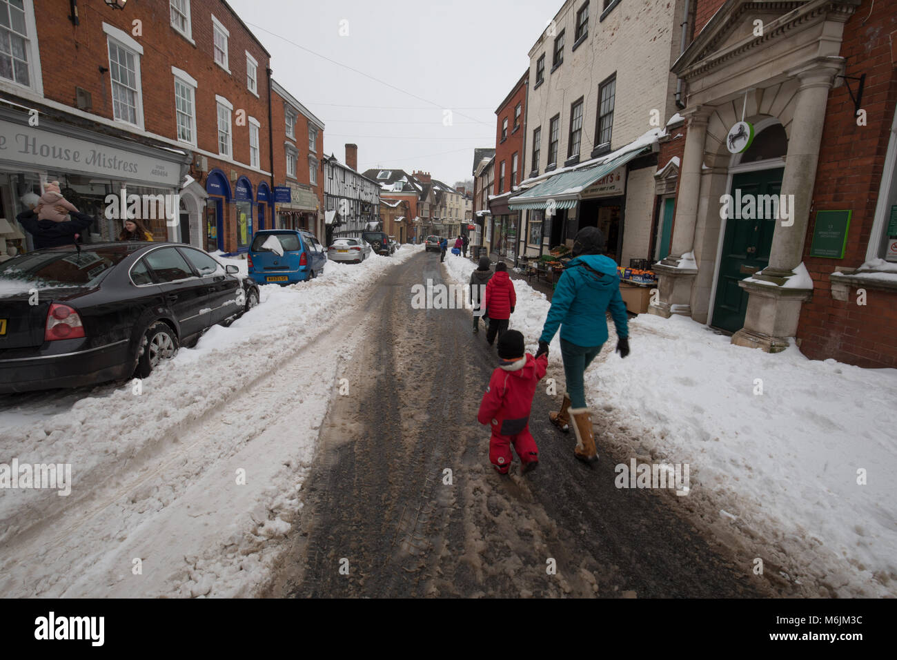 Local residents heading out and about in Bromyard. A rural town experiencing weather disruption in the winter of 2018. Stock Photo