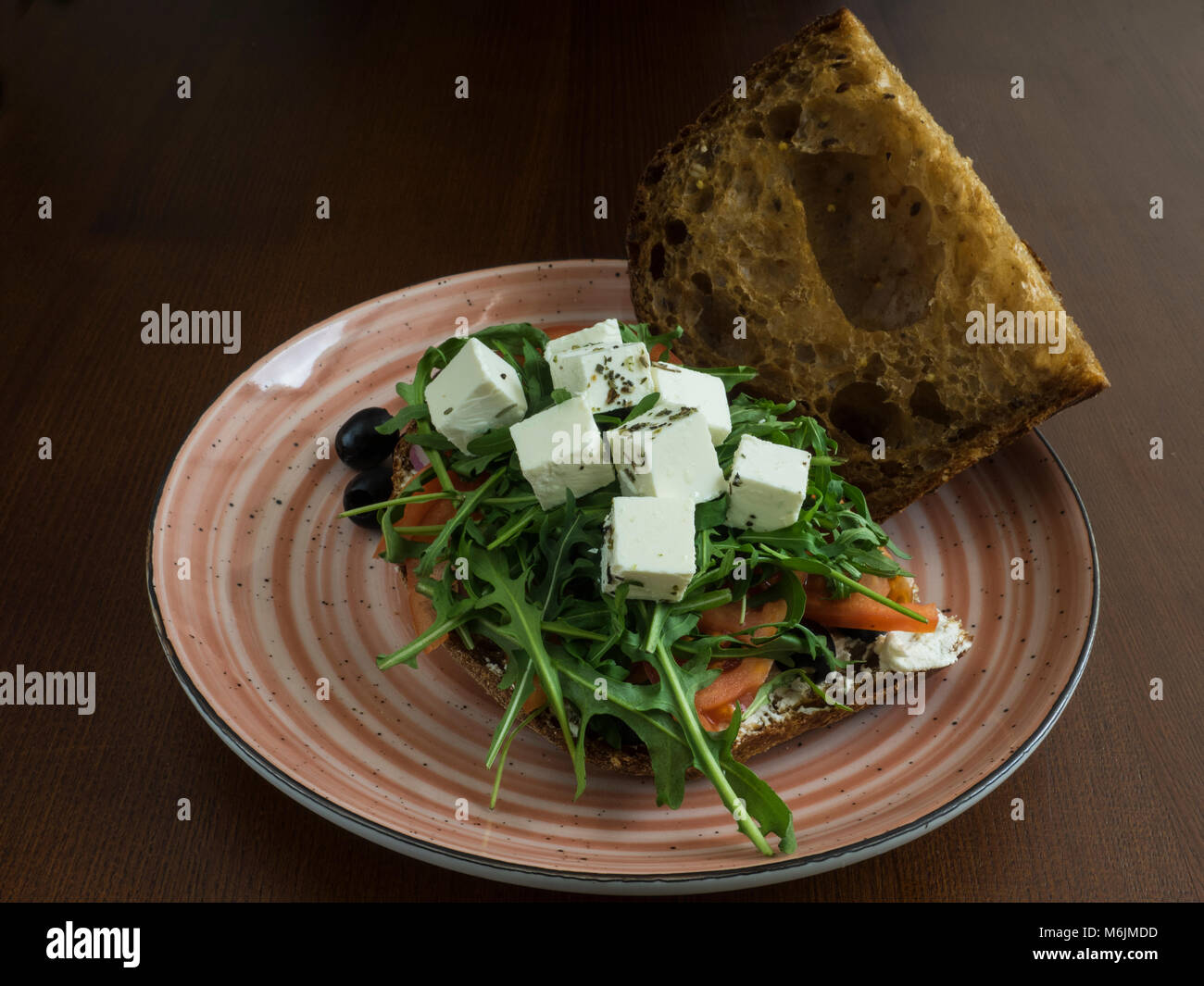 sandwich with feta cheese, tomatoes, olives, red onions and arugula