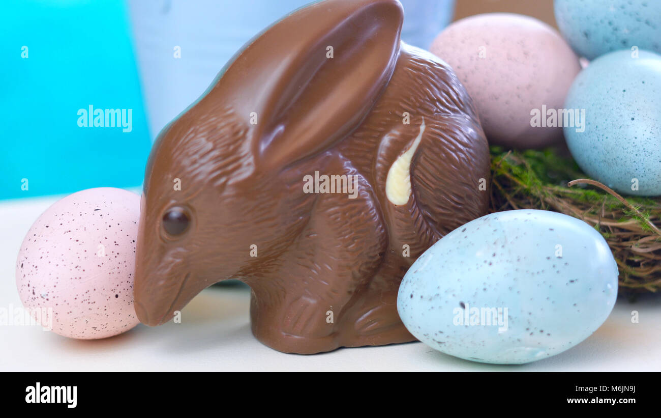 Australian milk chocolate Bilby Easter egg with eggs in nest against a blue and white background Stock Photo