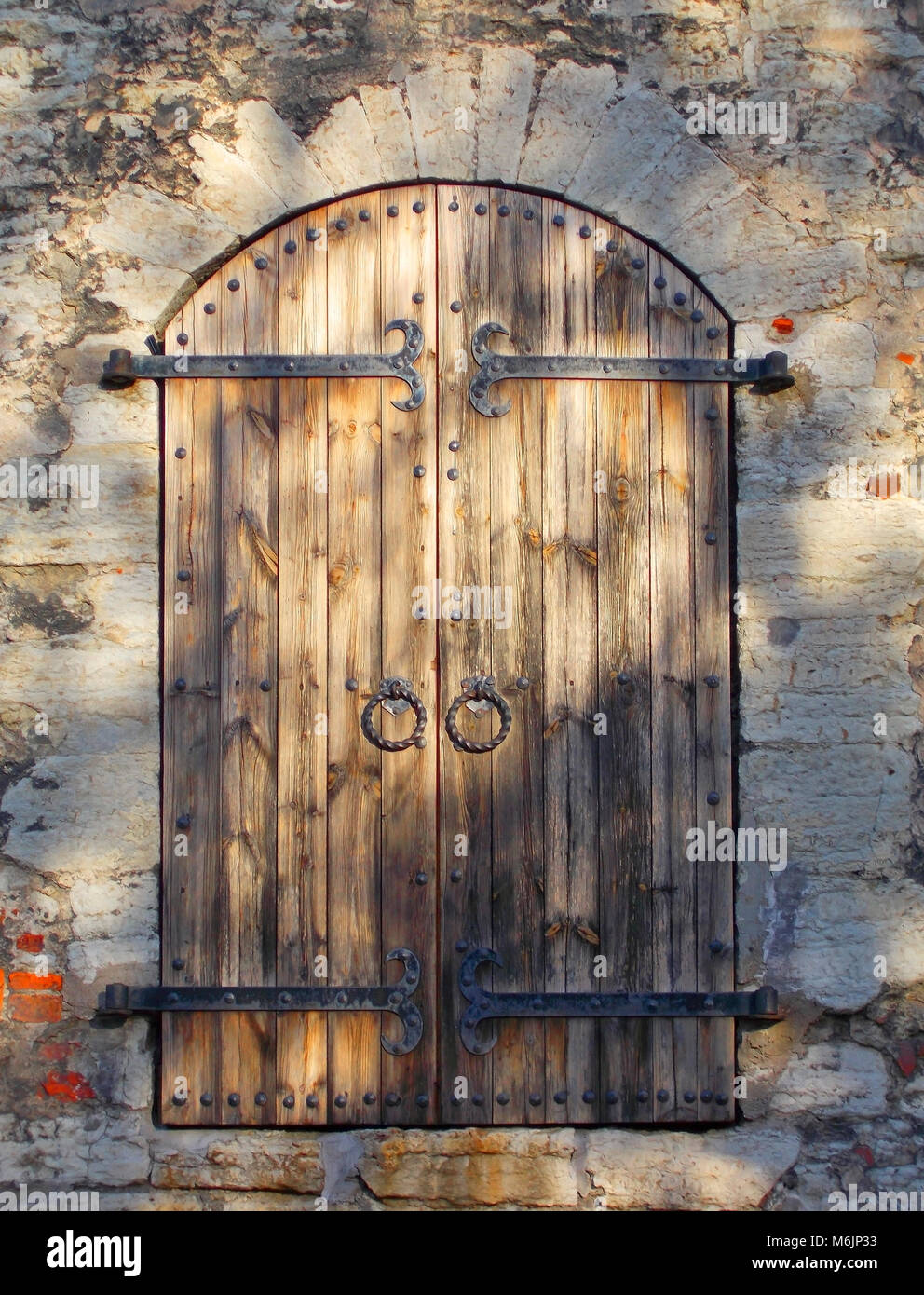 Wood and wrought iron Door in a Stone wall Stock Photo - Alamy