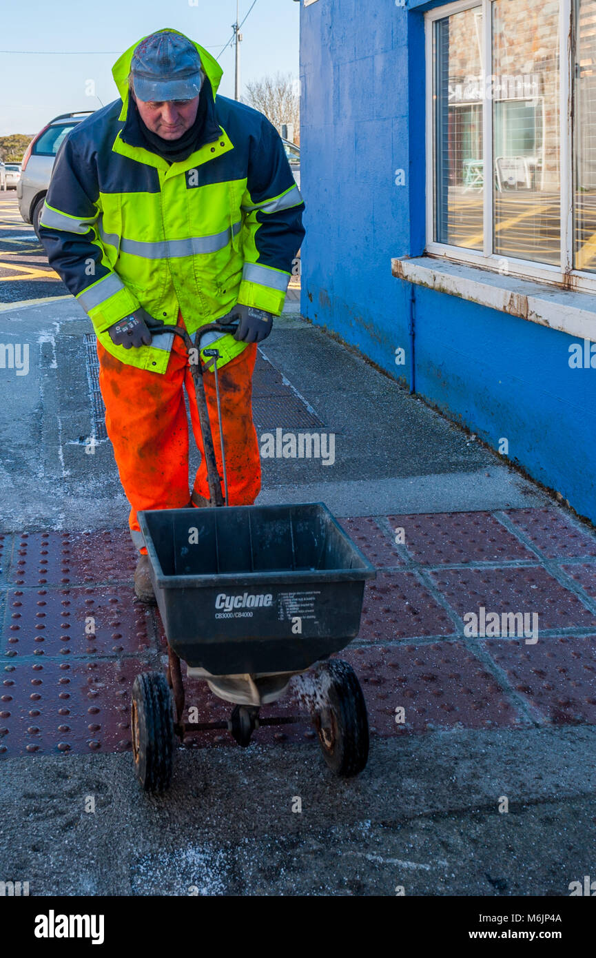 Cork County Council worker gritting the pavement during Storm Emma in Schull, County Cork, Ireland. Stock Photo