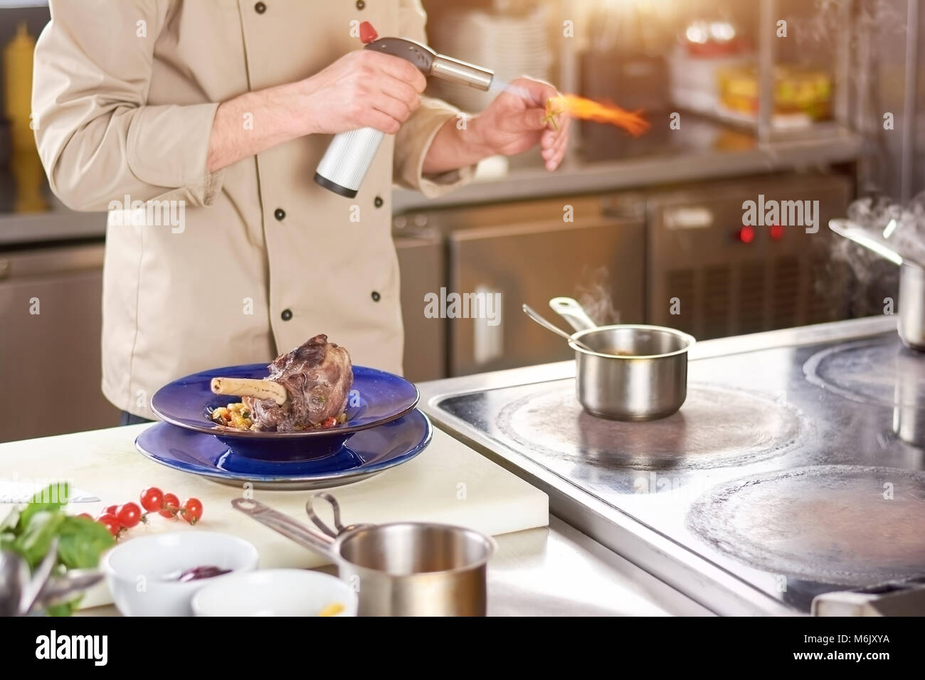 Chef hands holding torch burner. Stock Photo