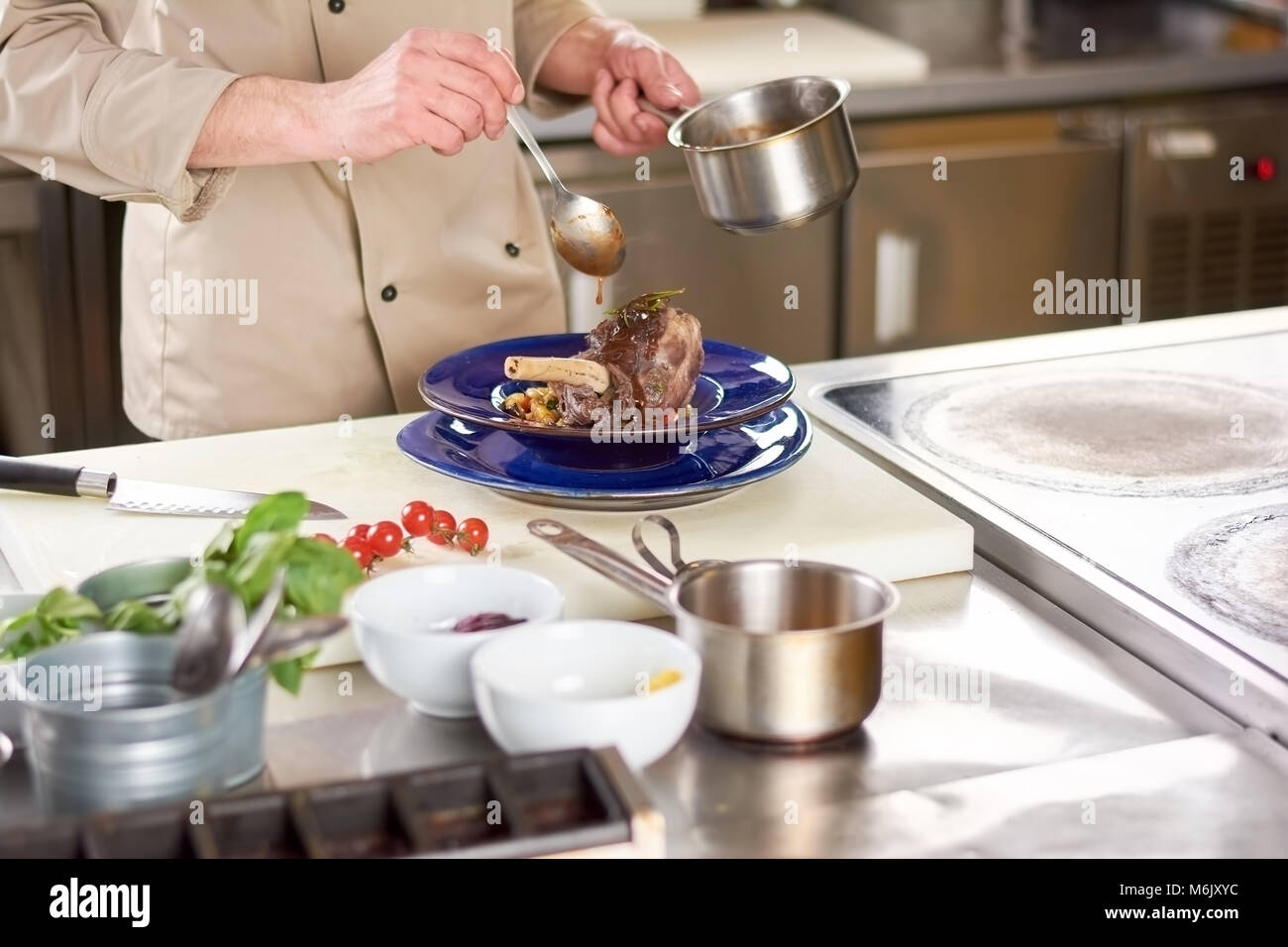Chef pouring with sause lamb shank. Stock Photo