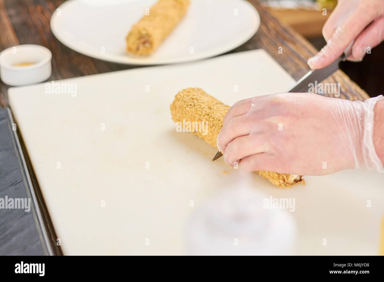 Chef hands with knife cutting sushi roll Stock Photo Alamy