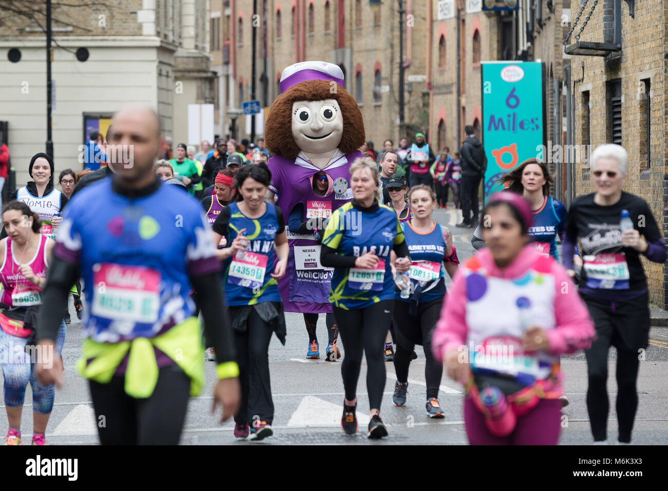 London, UK. 4th March 2018. Mass runners and a fancy dress runner as a giant doll in Wapping as they approach the half way point of the 2018 Vitality Big Half Marathon. Credit: Vickie Flores/Alamy Live News Stock Photo