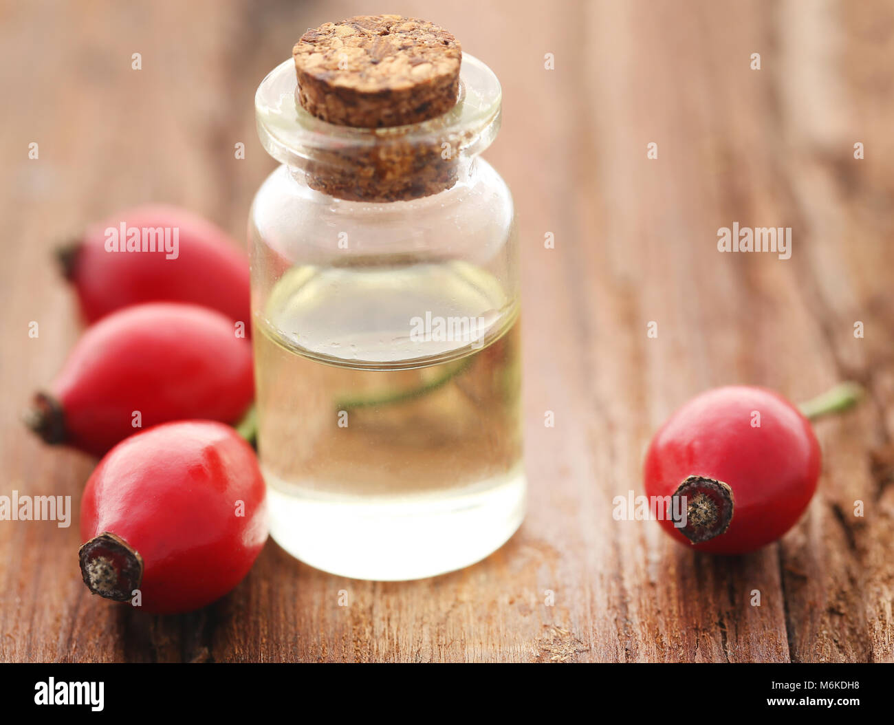 Medicinal Rose hips with essential oil in a glass bottle Stock Photo ...