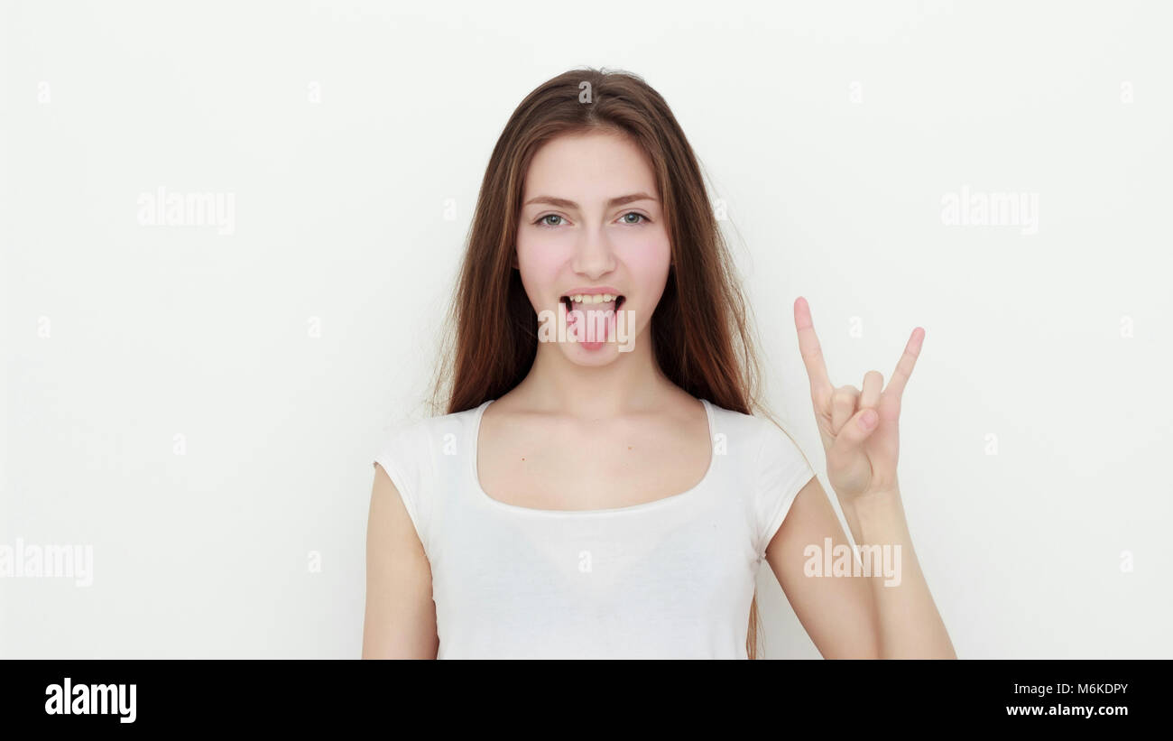 Pretty funny young girl showing tongue and rock gesture Stock Photo