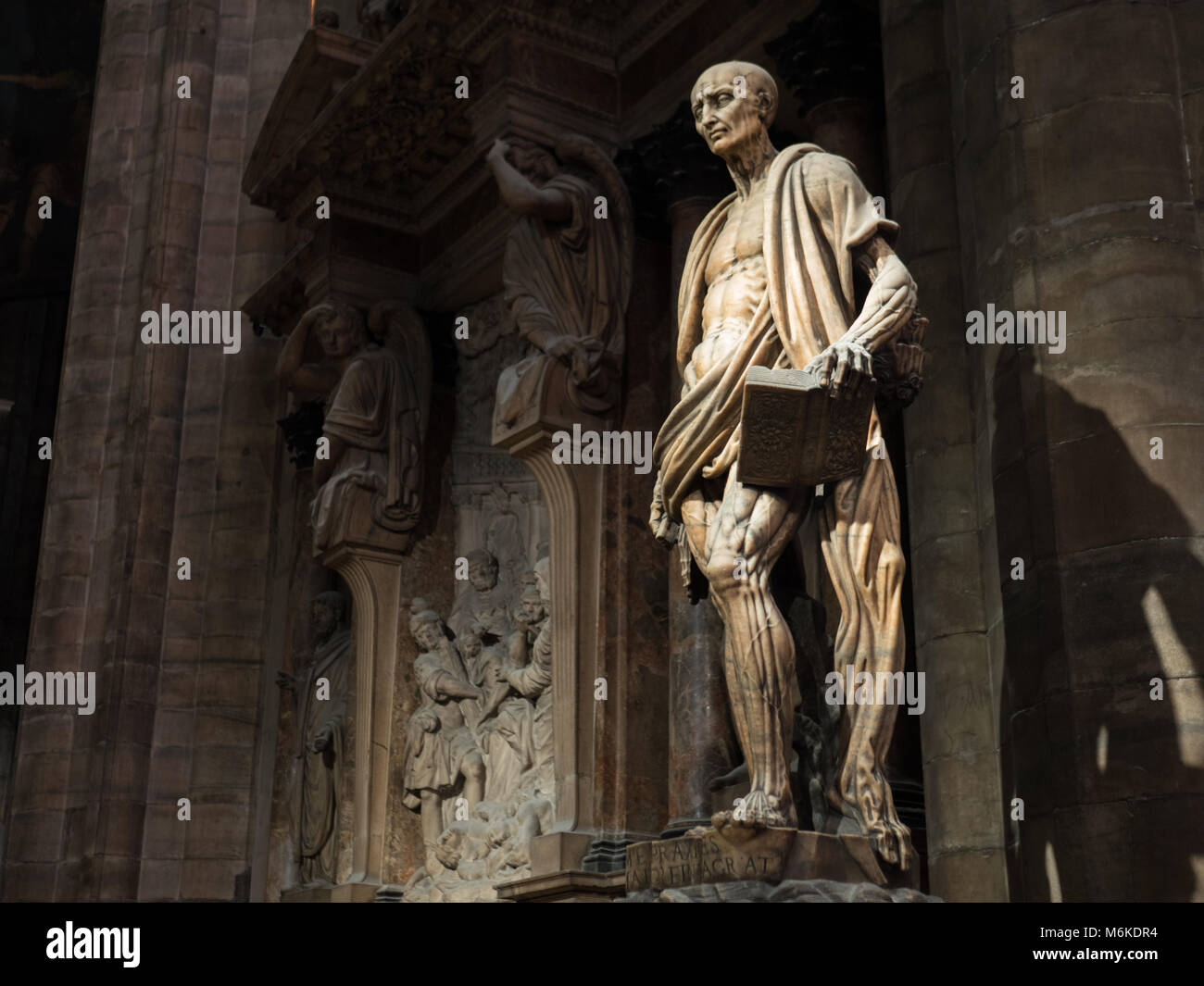 This statue rests within the Milano cathedral, and depicts st. Bartholomew. The drapery is in fact his skin, since he was flayed. Stock Photo