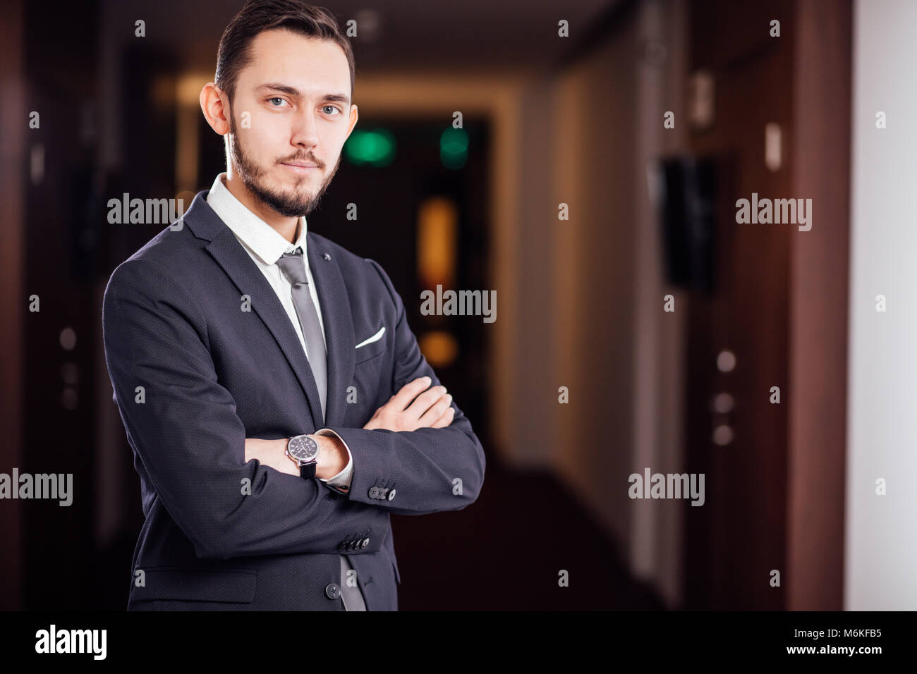 happy businessman with arms crossed standing in office Stock Photo - Alamy
