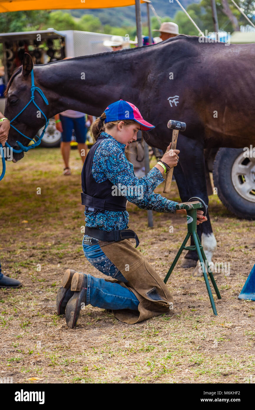 Young competitor adjusting a horse shoe for her horse during the King