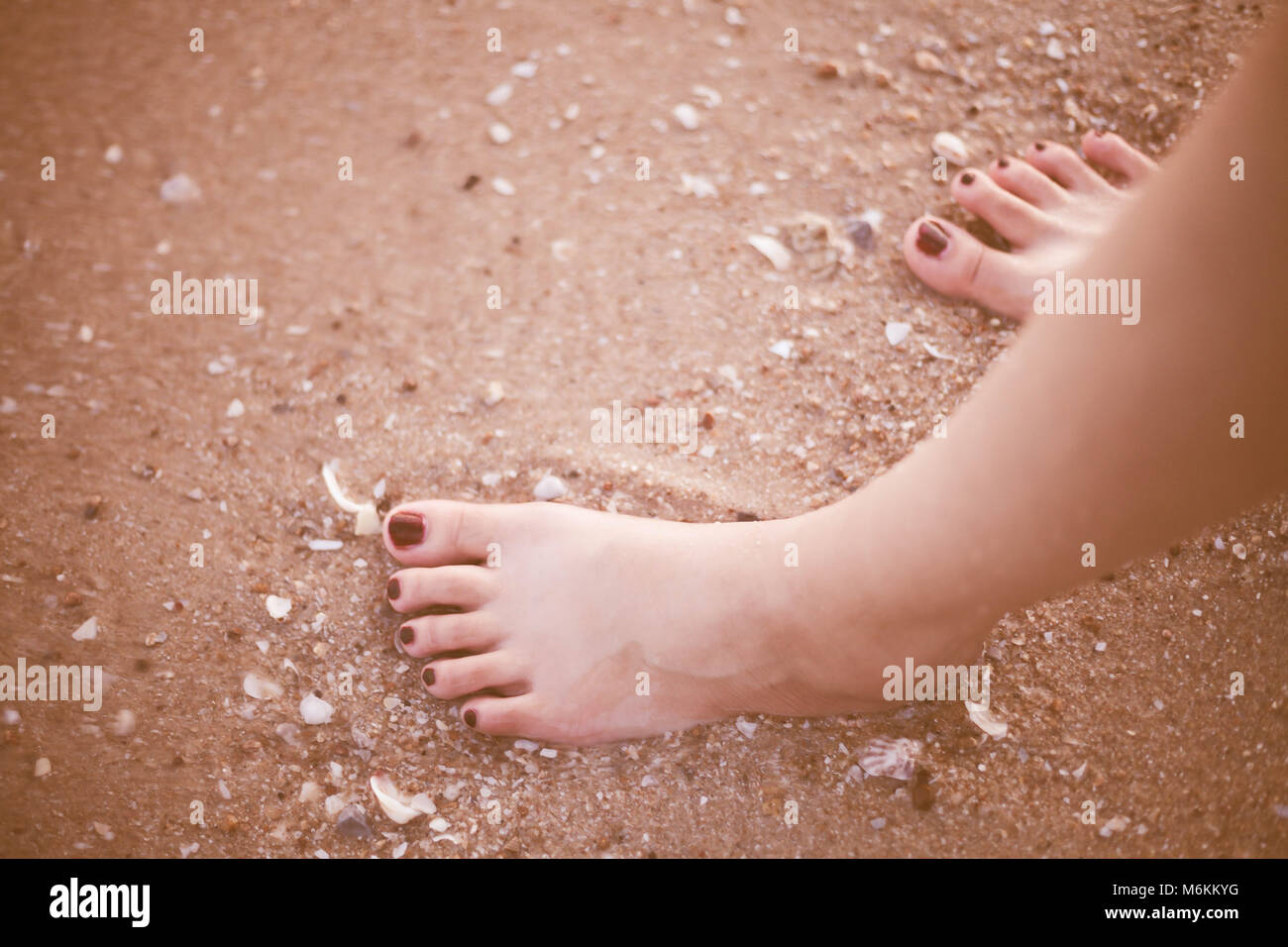 Barefoot female legs on sand beach closeup Stock Photo - Alamy